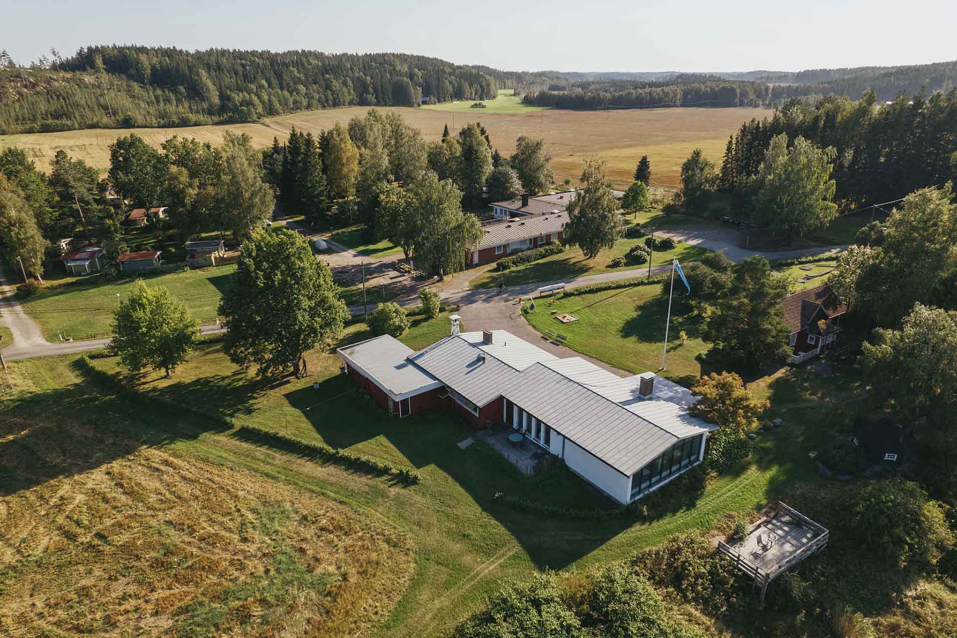 Kuusiston lomakeskuksen ravintola-rakennus, taustalla asuntola. Luonnonrauhaa merenrannalla.
